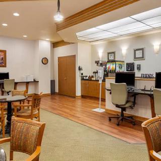A modern office workspace featuring computers, chairs, and tables.