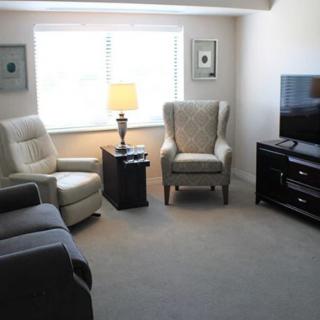 A cozy living room with comfortable seating, a lamp, and a TV.