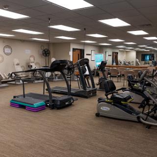 A view of a fitness center featuring various exercise machines, including treadmills and other workout equipment.