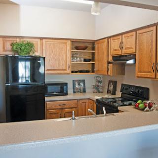 A modern kitchen featuring wooden cabinetry and essential appliances.