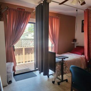 A cozy bedroom with a bed, curtains, and access to a balcony.