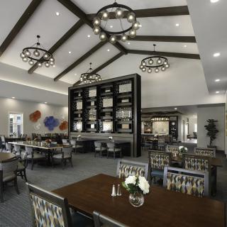 A modern restaurant interior featuring elegant chandeliers and arranged dining tables.