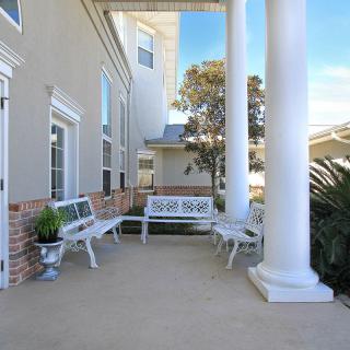 Sunny porch with benches and decorative columns.