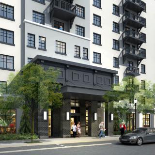A modern urban apartment building with a sleek exterior and street-level entrance.