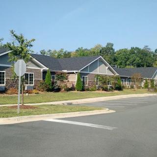 A quiet suburban neighborhood street lined with modern houses and greenery.