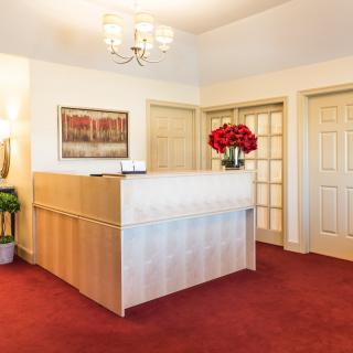 A well-decorated office reception area with a red carpet and elegant lighting.