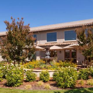 A two-story residential house with a well-maintained garden and landscaping.
