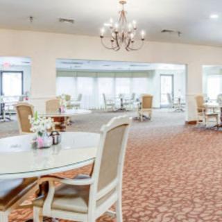 A spacious dining area with elegant furniture and a chandelier.
