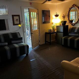 A cozy living room with comfortable seating, warm lighting, and a doorway leading outside.