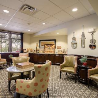 A cozy lounge with comfortable seating and musical artwork on the wall.