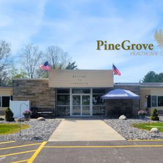 The welcoming front entrance of Pine Grove, showcasing a beautifully landscaped area and the American flag.