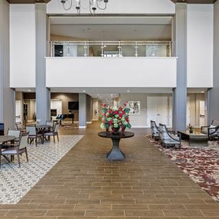 Elegant hotel lobby with seating areas and floral centerpiece.