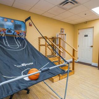 An indoor basketball arcade game set up in a recreation room.