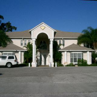 A suburban residential house with a grand entrance and a vehicle parked in the driveway.