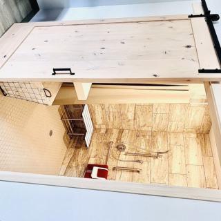 A wooden indoor rabbit hutch featuring multiple levels and sections for pets.