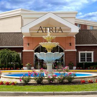 Atria retirement home entrance with a decorative fountain and landscaped flowers.