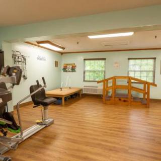 A spacious and well-lit gym area equipped for physical therapy and fitness activities.