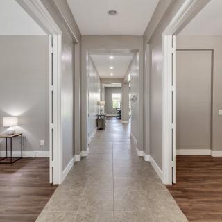 A modern hallway with elegant lighting and contrasting flooring.