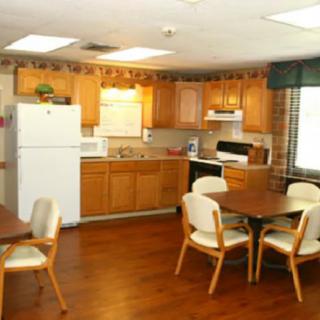 A spacious kitchen and dining area with wooden cabinets and furniture.