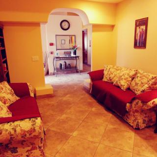 A cozy living room with floral sofas and warm lighting.