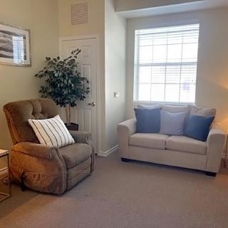 A cozy living room with a sofa, armchair, and decorative items.