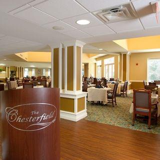 Elegant dining area with neatly arranged tables and chairs in a well-lit restaurant interior.
