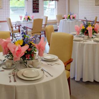 Elegantly set tables with floral centerpieces in a dining area.