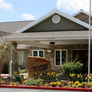 Front view of a building entrance with landscaping and a welcoming sign.