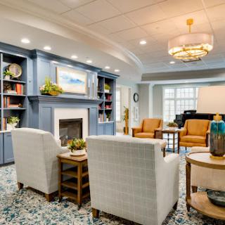 A cozy and inviting living room space featuring modern furniture, a decorative fireplace, and stylish bookshelves.