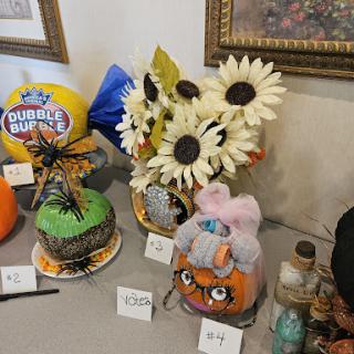 A vibrant display of creatively decorated pumpkins and floral arrangements, showcasing the festive spirit of Halloween.
