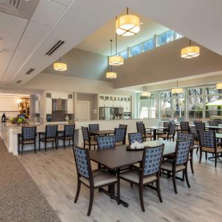 A modern dining area with elegant lighting and neatly arranged furniture.