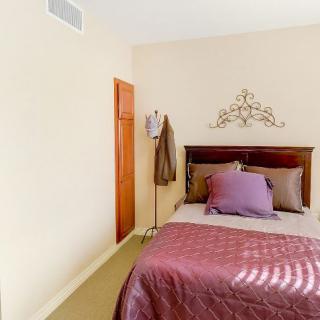 A cozy bedroom with a decorative headboard and warm-colored bedding.