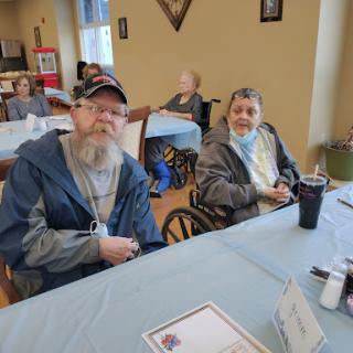 Two elderly men enjoying time together in a community setting.