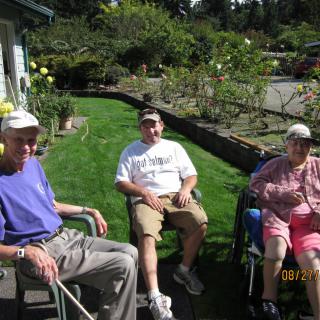A group of seniors relaxing in the garden on a sunny day.