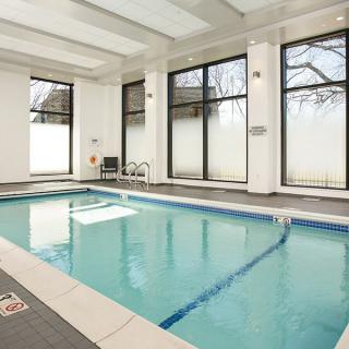 A serene indoor swimming pool with large windows and a clean, modern design.