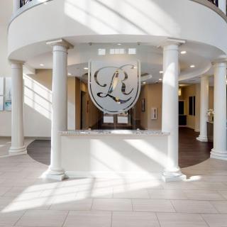 A bright and elegant lobby entrance with columns and a decorative emblem.