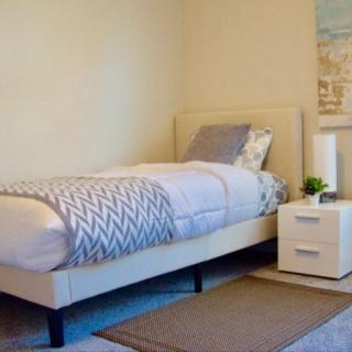 A minimalist bedroom with a single bed and nightstand.