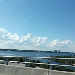 A scenic view of water under a clear blue sky, captured from a bridge.