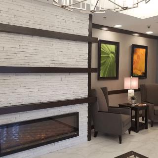 A modern lobby with a fireplace, seating area, and abstract artwork.