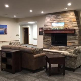 A cozy living room featuring a stone fireplace and comfortable seating.