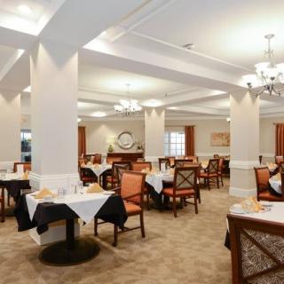 A spacious and elegantly decorated dining room with tables and chairs set for service.