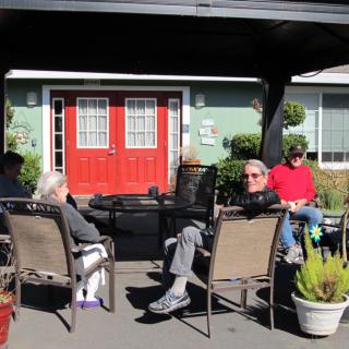 A group of people relaxing and socializing in an outdoor garden area.