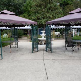 A serene outdoor space featuring two gazebos and a central fountain, perfect for relaxation.