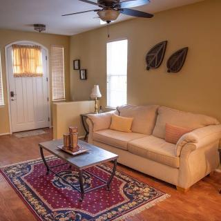 A cozy living room with a beige sofa, wooden coffee table, and a patterned rug.