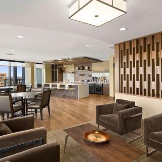 A modern open-concept living space featuring a kitchen and sitting area with elegant wood finishes.