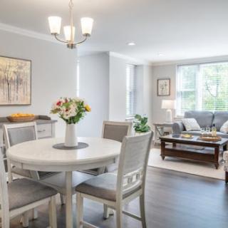 A beautifully arranged dining area connected to a cozy living space, featuring modern furniture and bright natural light.