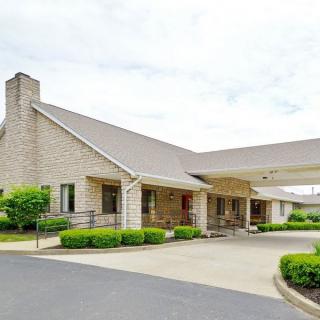 A suburban house with a covered driveway and landscaped greenery.