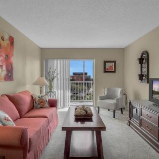A cozy living room with a sofa, coffee table, and TV overlooking a balcony.
