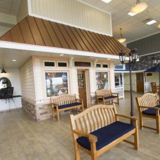 A spacious indoor waiting area featuring wooden benches and warm lighting.