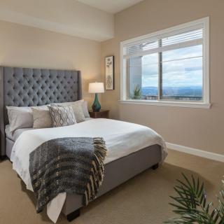 A modern bedroom with a large bed and scenic window view.